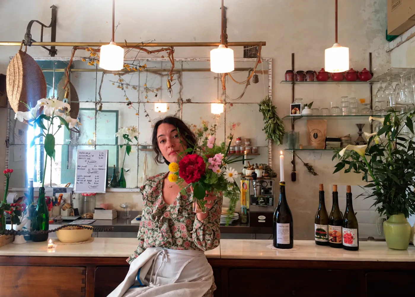Gaby Mangeri detrás de la barra de Jugo, ofreciendo un ramo de flores