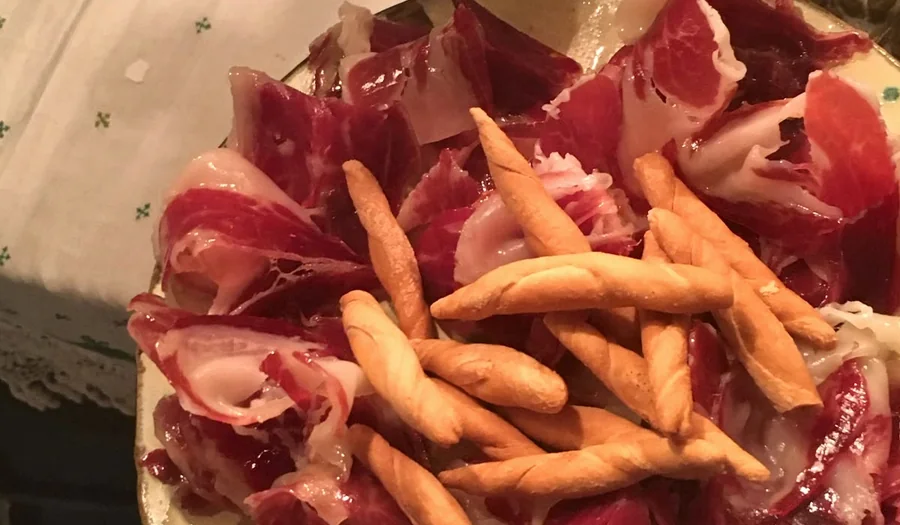Jamón ibérico en una bandeja de cerámica, con picos